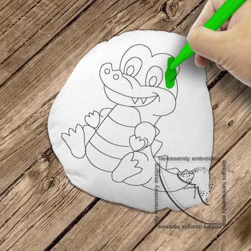 Image of design DD003 of a smiling crocodile cuddly colouring in stuffie, with child's hand colouring it in 